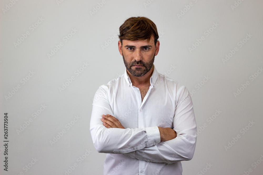 Fashion portrait of handsome young man with brown hair and a serious expression, looking at the camera. Isolated on white background. Fashion portrait of handsome young man with brown hair and a serious expression, looking at the camera. Isolated on white background.