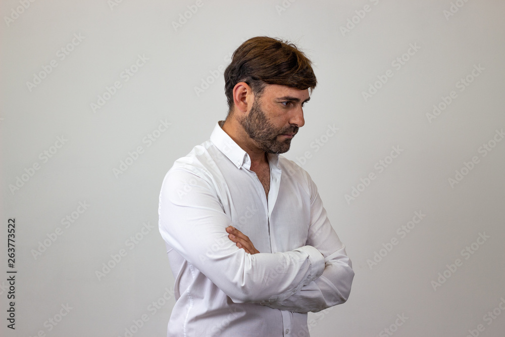Fashion portrait of handsome young man with brown hair and a serious expression, facing forwards and looking at the side. Isolated on white background. Fashion portrait of handsome young man with brown hair and a serious expression, facing forwards and looking at the side. Isolated on white background.
