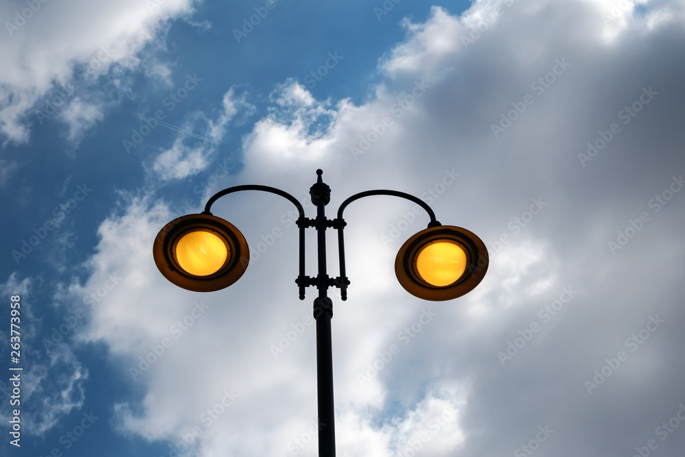 city lit light pole on day with cloudy sky city lit light pole on day with cloudy sky