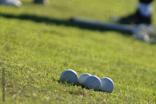 Close up picture of lacrosse balls on the green field.