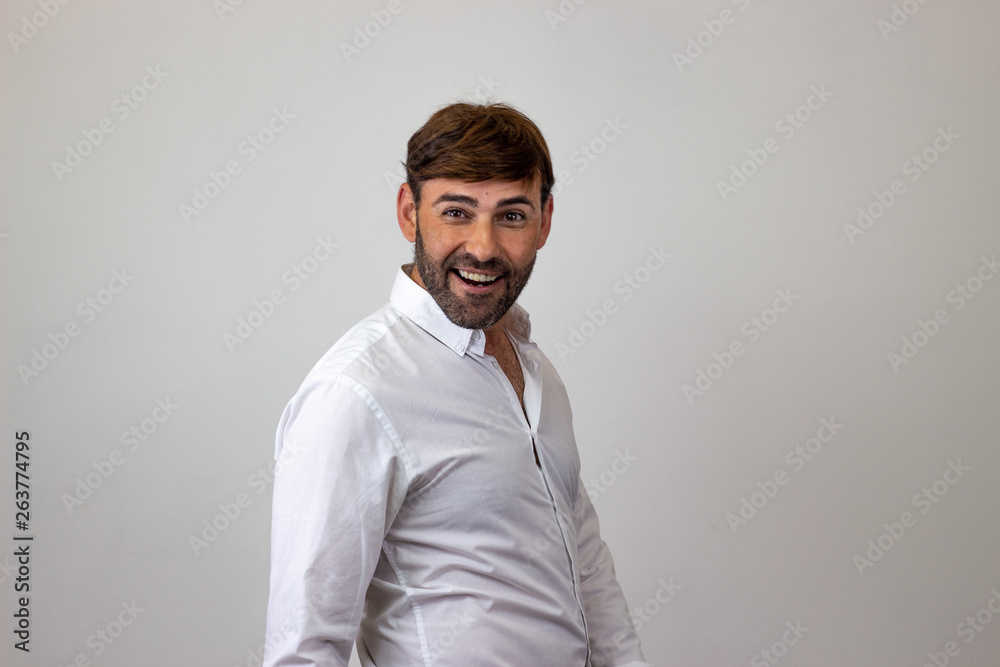Fashion portrait of handsome young man with brown hair looking happy, their back facing the camera and looking at the camera. Isolated on white background. Fashion portrait of handsome young man with brown hair looking happy, their back facing the camera and looking at the camera. Isolated on white background.
