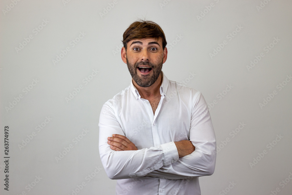 Fashion portrait of handsome young man with brown hair looking surprised, looking at the camera. Isolated on white background. Fashion portrait of handsome young man with brown hair looking surprised, looking at the camera. Isolated on white background.