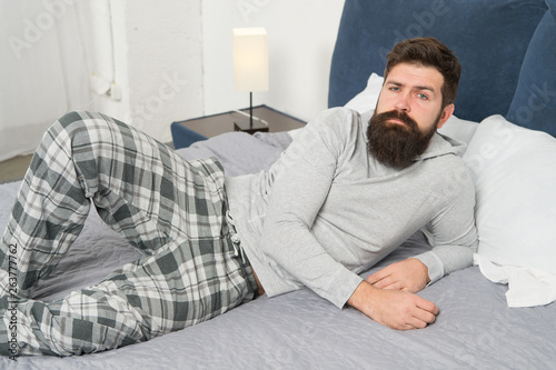 Just one more minute in bed. energy and tiredness. bearded man hipster want to sleep in morning. brutal sleepy man in bedroom. mature male with beard in pajama on bed. asleep and awake. comfort bed