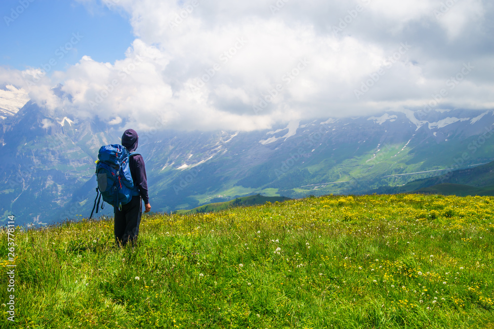 Hiker traveling in Alps. Alpine peaks landskape background. Jungfrau, Bernese highland. Sport, tourism and hiking concept. Hiker traveling in Alps. Alpine peaks landskape background. Jungfrau, Bernese highland. Sport, tourism and hiking concept.