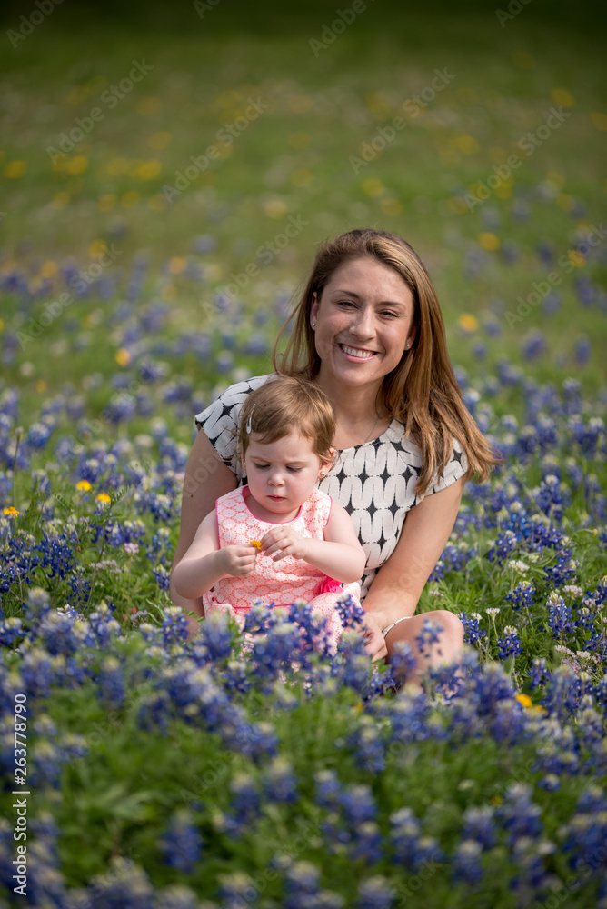 Young Millennial Mother With Daughter During Spring in a Field of Blue Bonnets Young Millennial Mother With Daughter During Spring in a Field of Blue Bonnets
