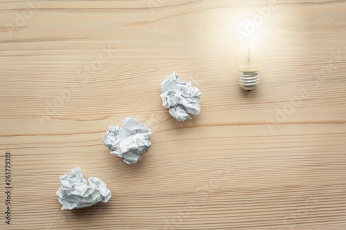 White crumpled paper balls folded in line with light bulb on the top. Concept of problem solution. Symbol of idea, innovation, inspiration, think different, think out of the box, leadership.