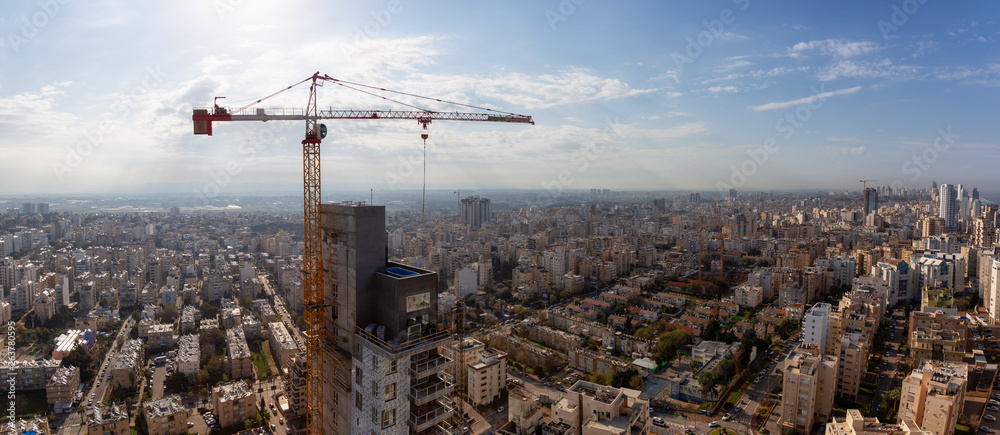 Netanya, Center District, Israel - April 1, 2019: Aerial panoramic view of a construction site in a city during a cloudy and sunny morning.