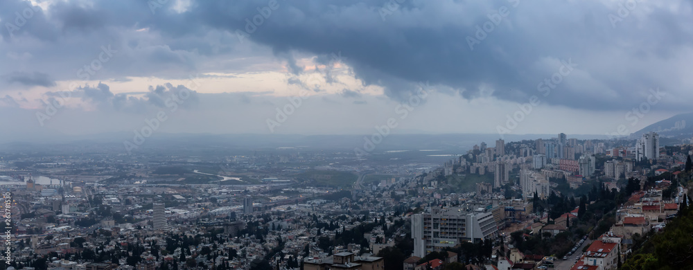 Fototapeta premium Beautiful panoramic view of a city on the coast of Mediterranean Sea during a cloudy sunset. Taken in Haifa, Israel.