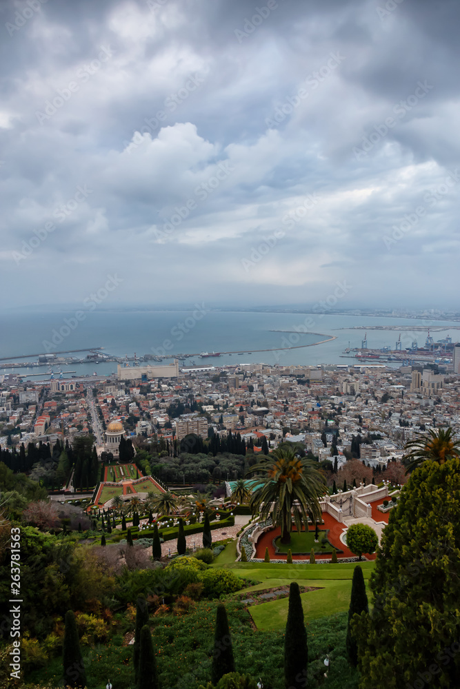 Beautiful view of Bahai Gardens and a city on the coast of Mediterranean Sea during a cloudy sunset. Taken in Haifa, Israel.