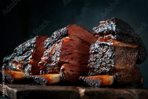 Foto Chopping board with Smoked beef brisket ribs, Classic Texas BBQ