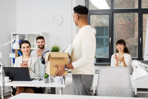 business, new job and quit concept - happy smiling office workers applauding for indian male colleague with box of personal stuff