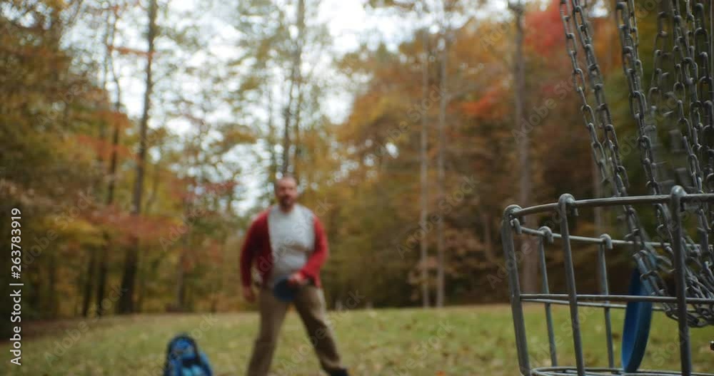 Man in Park Making Disc Golf Putt with Fall Leaves. Man in Park Making Disc Golf Putt with Fall Leaves.