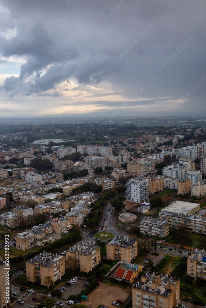 Fototapeta premium Aerial view of a residential neighborhood in a city during a cloudy sunrise. Taken in Netanya, Center District, Israel.