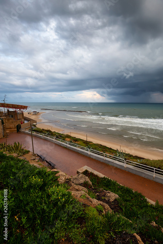 Beautiful view of a sandy beach during a cloudy sunrise. Taken in Netanya  Center District  Israel.
