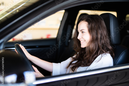 Attraktive junge Frau freudig lächelnd in einem Auto 