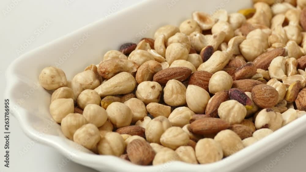 nuts, peeled hazelnuts, cashews and almonds, stand together, nuts, cashew nuts, dry almonds all on a plate close up nuts, peeled hazelnuts, cashews and almonds, stand together, nuts, cashew nuts, dry almonds all on a plate close up