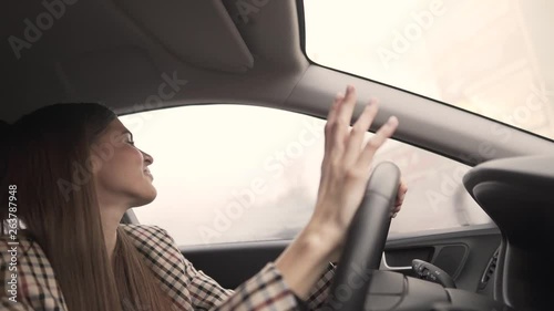 Wallpaper Mural Very sexy brunette with long hair sitting and driving in the car while singing the song to the fullest. She is very positive and tapping on the car's wheel Torontodigital.ca