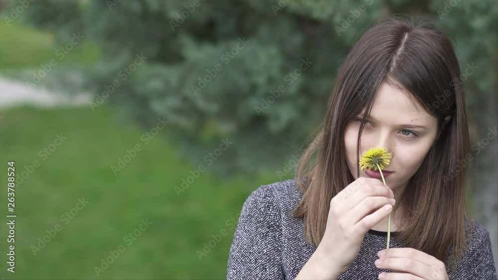 Beautiful Young Woman Holding a Yellow Flower in the Park, Slow Motion Shot Beautiful Young Woman Holding a Yellow Flower in the Park, Slow Motion Shot