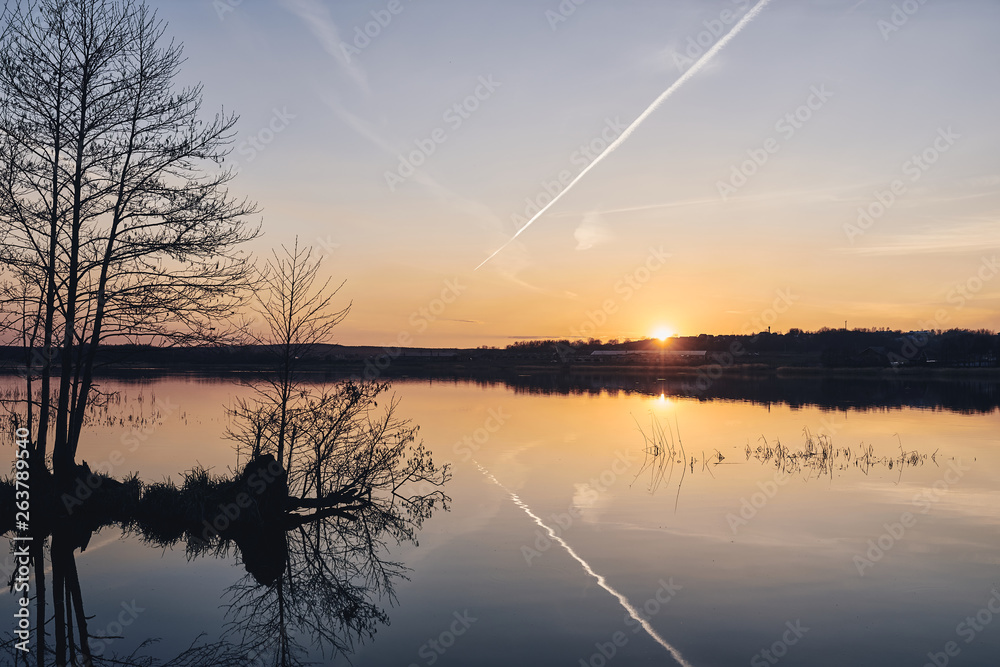 Sunset on the lake in the forest. Beautiful landscape.
