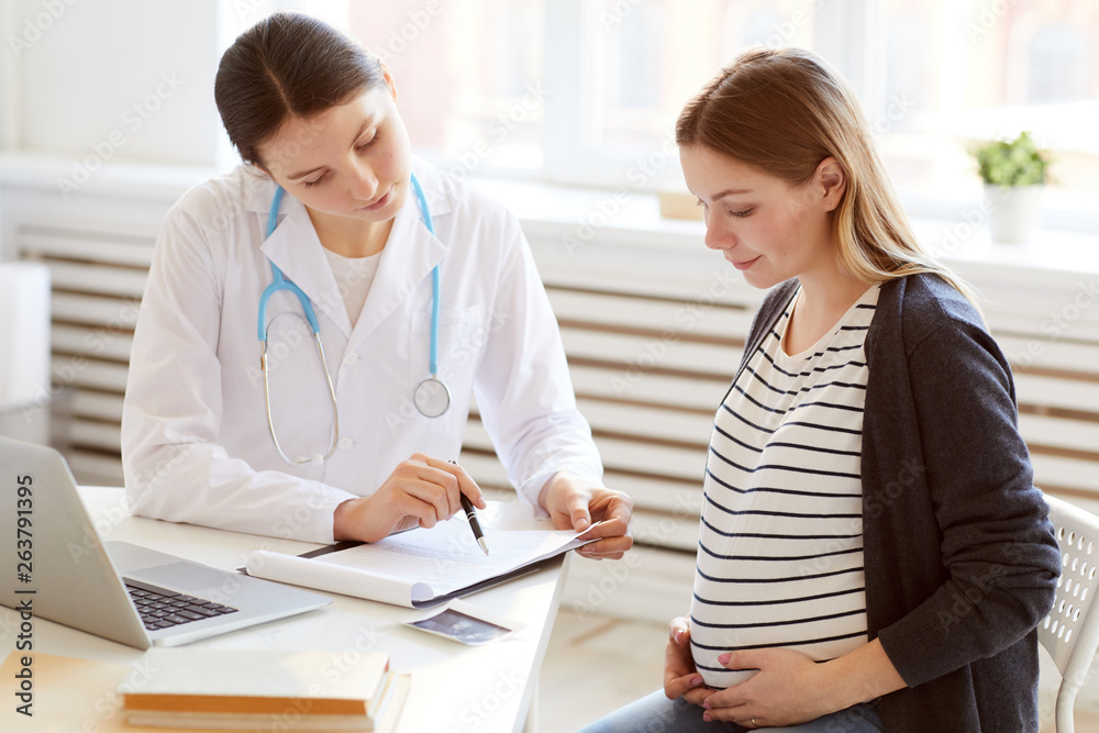 Portrait of female obstetrician consulting pregnant woman in doctors office, copy space Portrait of female obstetrician consulting pregnant woman in doctors office, copy space