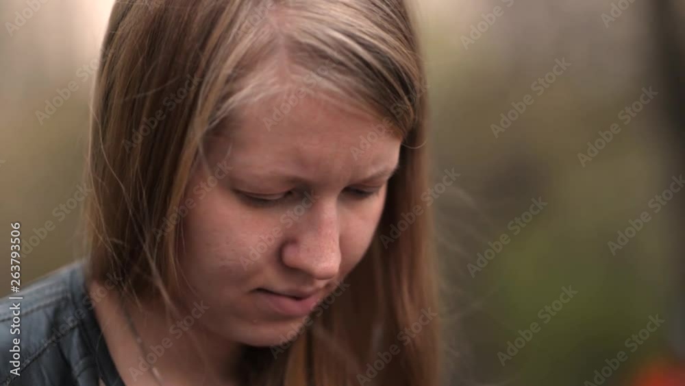 Beautiful blonde young girl looking at something close up face cloud day Beautiful blonde young girl looking at something close up face cloud day