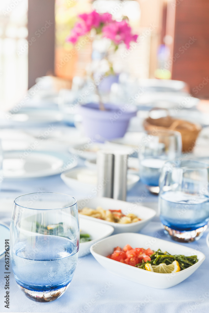 Fototapeta premium Varioius meze starters in an outdoor greek restaurant. Healthy vegetarian snacks. Local mediterranean cuisine