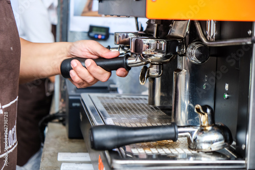 Espresso pouring machine with barista hand close up