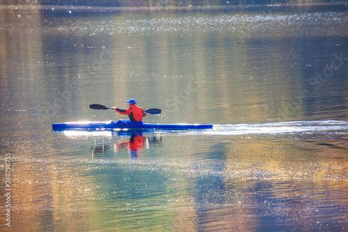 sportsman engaged in canoeing on a river