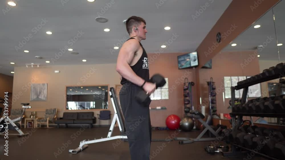 Person lifting weights and exercising in the gym. Zoom in. 24 fps. Shot in 4k exported in 1080p. Shallow depth of field. Person lifting weights and exercising in the gym. Zoom in. 24 fps. Shot in 4k exported in 1080p. Shallow depth of field.