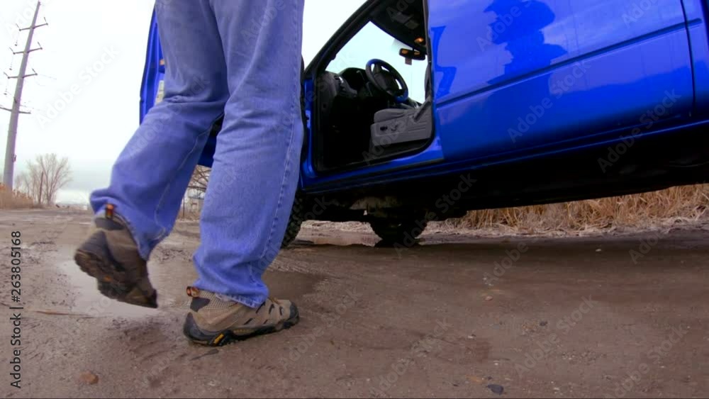 Man getting in a truck or large vehicle and steps in a puddle - slow motion Man getting in a truck or large vehicle and steps in a puddle - slow motion