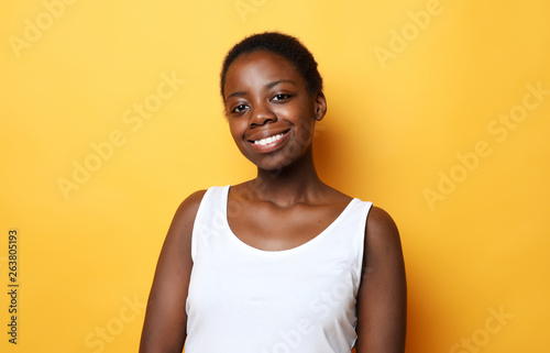 happy young african woman isolated over yellow background © Raisa Kanareva