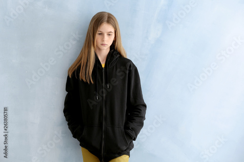 Sad teenage girl on color b...