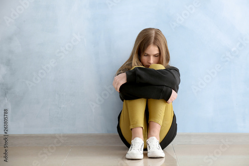 Sad teenage girl near color...