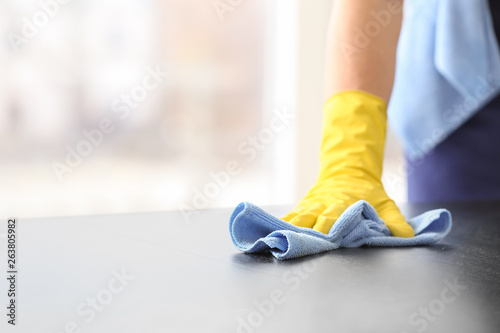 Male janitor cleaning table in office, closeup photo