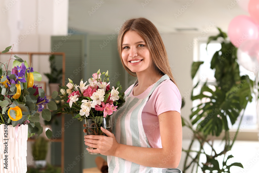 Female florist with beautiful bouquet in shop