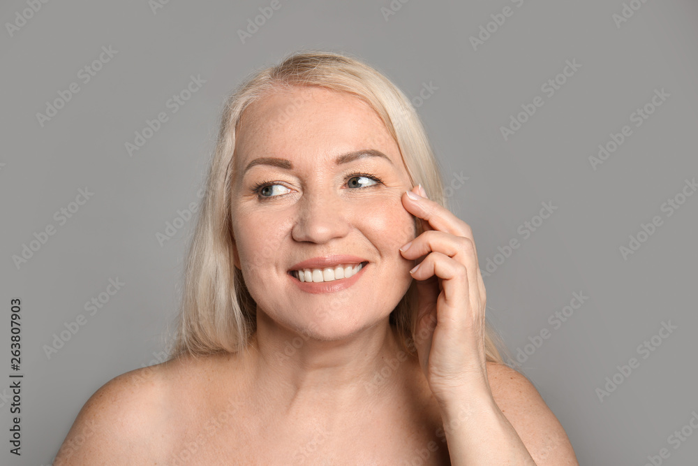 Mature woman with healthy skin on grey background Mature woman with healthy skin on grey background
