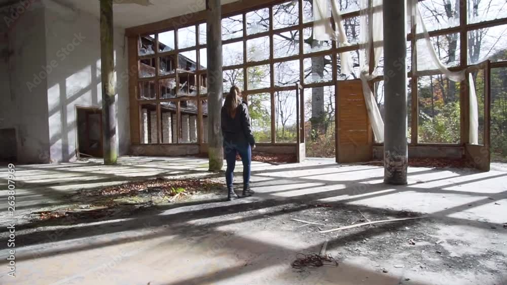 Young woman walking in abandoned mansion, urban exploration tracking shot Young woman walking in abandoned mansion, urban exploration tracking shot