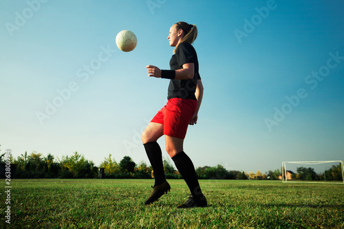 Female soccer player shoot the ball