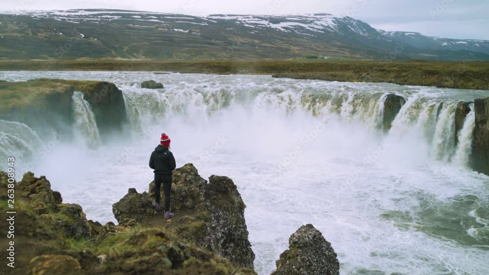 Woman standing on top of Godafoss Goðafoss, near Myvatn, Iceland. Female photographer. Woman standing on top of Godafoss Goðafoss, near Myvatn, Iceland. Female photographer.