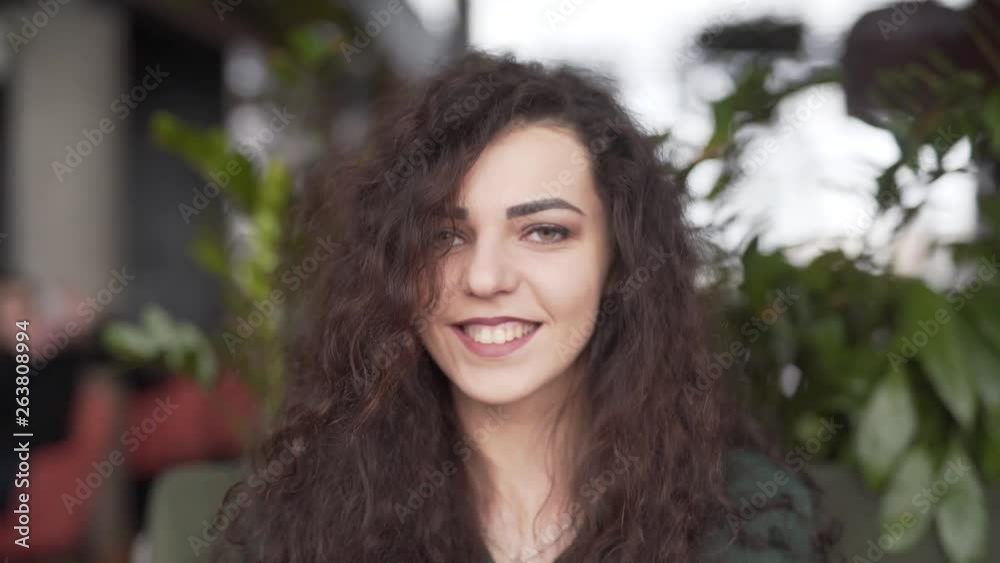 Smiling young woman takes off her glasses while looking at the camera. Smiling young woman takes off her glasses while looking at the camera.