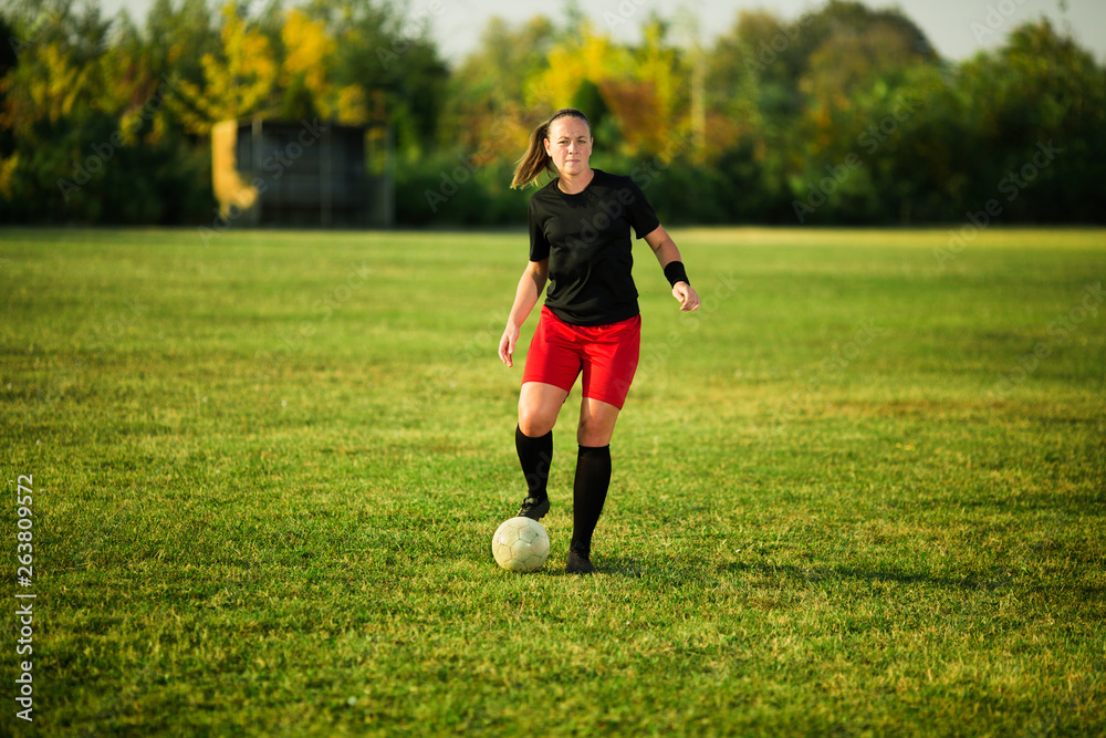 Female soccer player shoot the ball