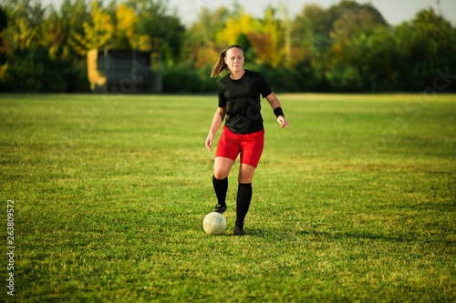 Female soccer player shoot the ball