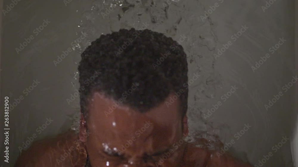 Angry African American man screaming under water in a bath tub