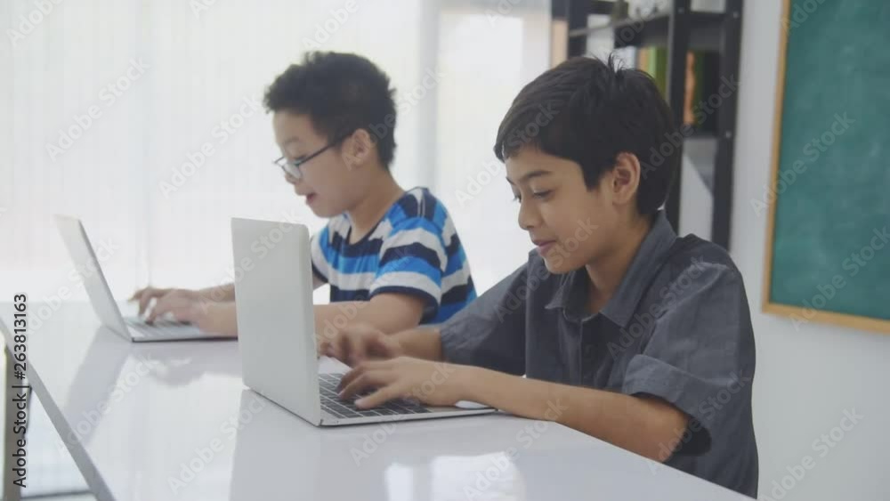 Young asian schoolboys studying with notebook computer in classroom Young asian schoolboys studying with notebook computer in classroom