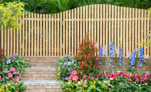 Fotografiet entrance and wooden fence of backyard flower garden