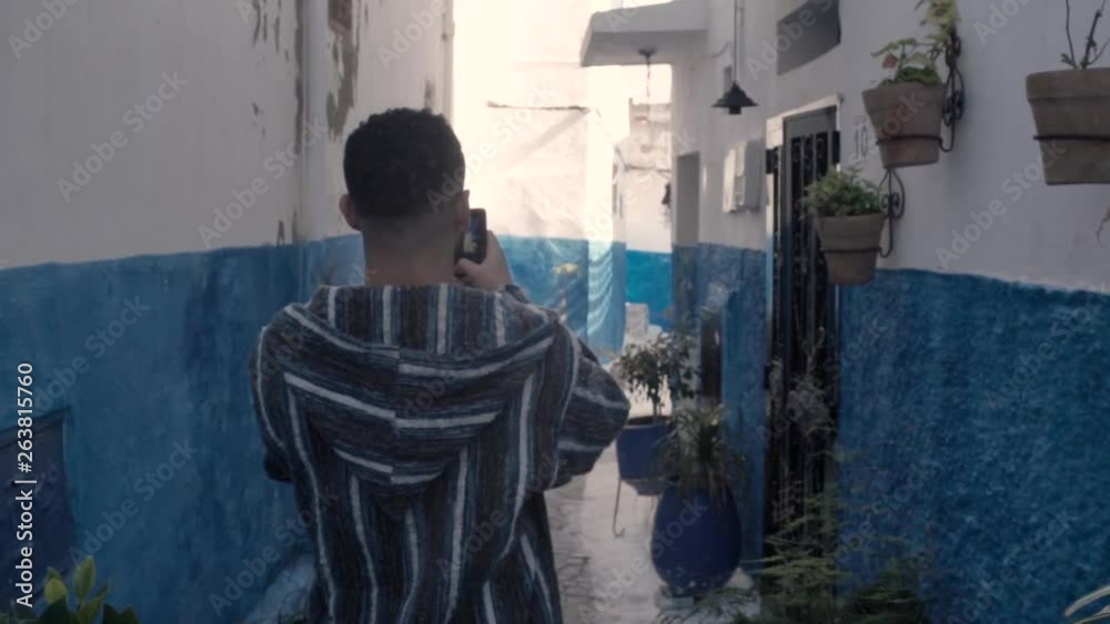 A tourist man taking pictures of a beautiful street in Chefchaouen city Morocco. exploring the blue city of Morocco A tourist man taking pictures of a beautiful street in Chefchaouen city Morocco. exploring the blue city of Morocco