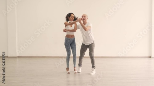 Caucasian Couple Partners in Light Colored Jeans Pants White Shirts anh Shoes Practicing Moves in Bright Dance Studio photo