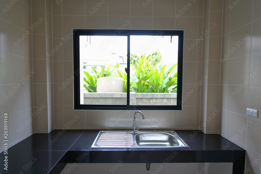 empty kitchen room cooking with stainless sink and built in black tile counter empty kitchen room cooking with stainless sink and built in black tile counter