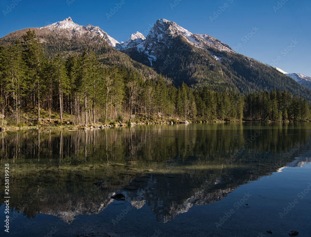 Schneebedeckte Berge spiegeln sich im Gebirgssee