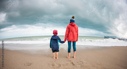 Barefoot boy with mother come into the sea.